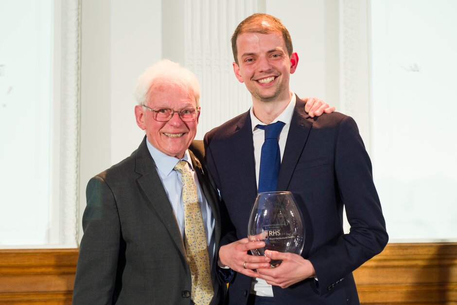 Josh Egan-Wyer & Roy Lancaster. Josh is holding a glass vase awarded to him by Roy.